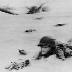 American Soldier Crawls through Heavy Surf on Omaha Beach