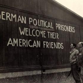 American Troops and Survivors look at Sign on Building