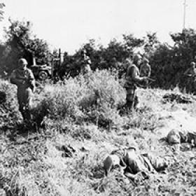 American Soldiers Proceed Cautiously through Hedgerows as American Casualties Lay in Foreground